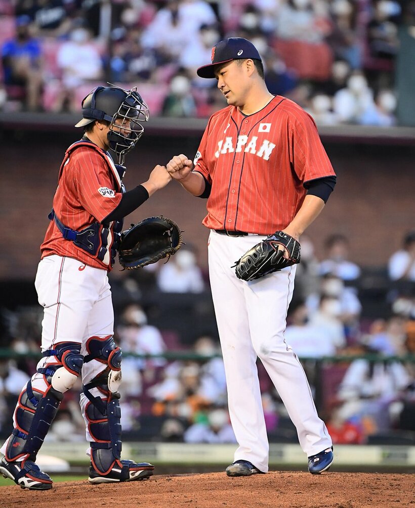  捕手の阪神・梅野(左)とグータッチする楽天・田中将