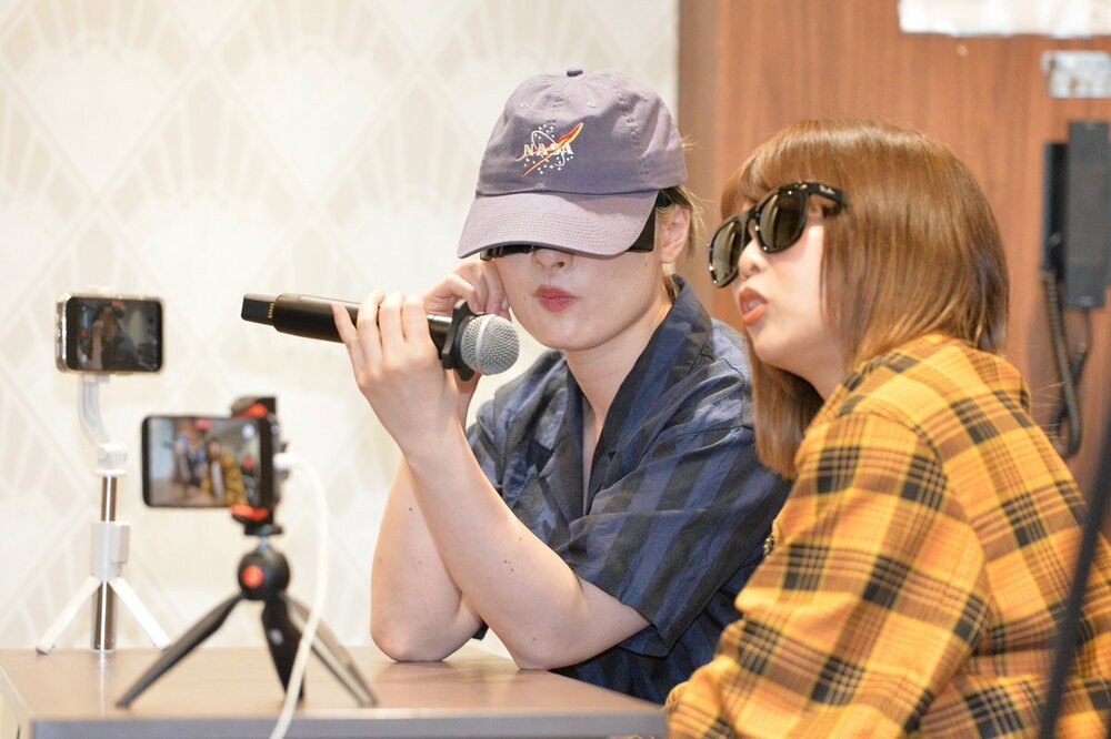 記者席に潜入するハイパーミサヲ(左)と中島翔子
