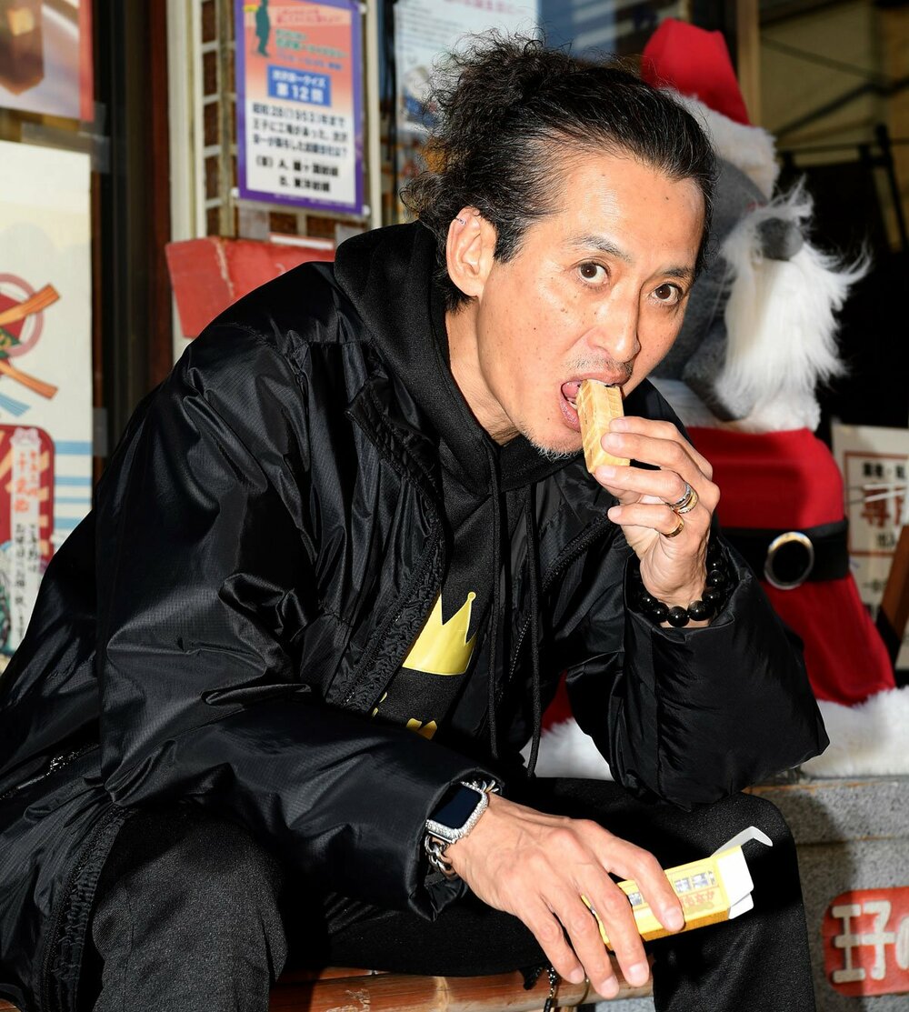 Mikio Osawa stuffing his mouth with the streetcar monaka at the Kajiwara shopping arcade