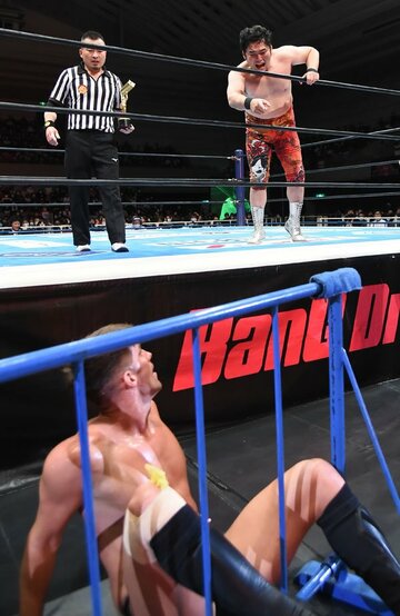  ザック(下)を場外に固定し、高笑いの矢野通(右上)