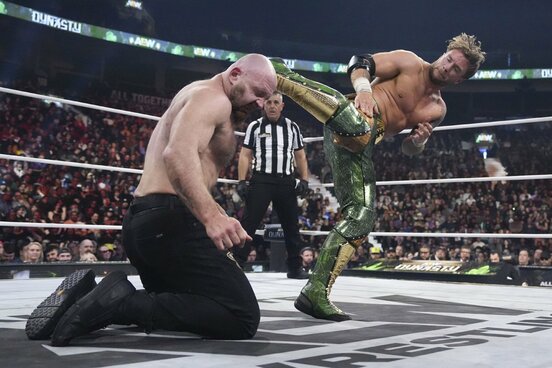 ウィル・オスプレイ（右）はジョン・モクスリーにヒハイキックを打ち込む ©All Elite Wrestling