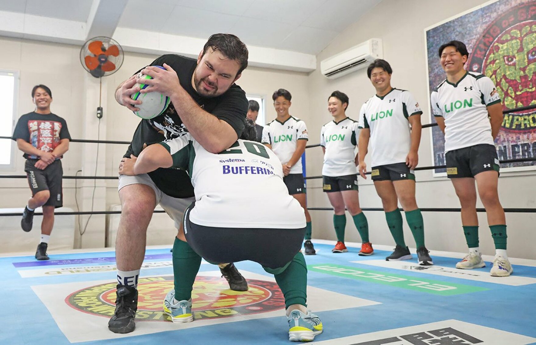 ウルフアロンは若手ラグビー選手にボールを持って突っ込む