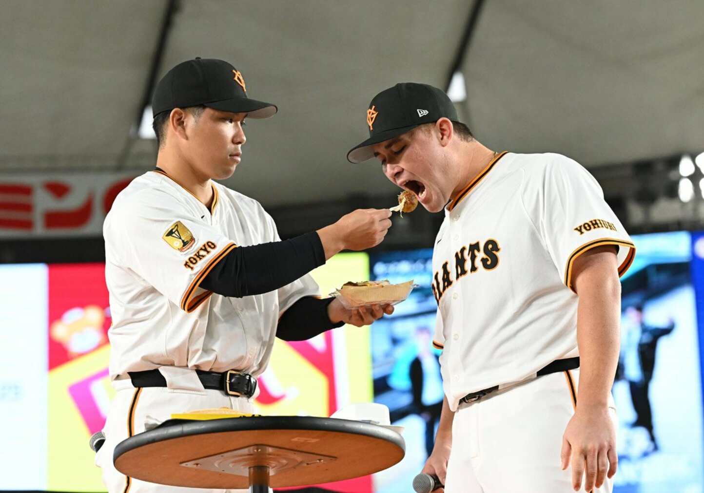 大城卓三（左）からたこ焼きを食べさせてもらうリチャード