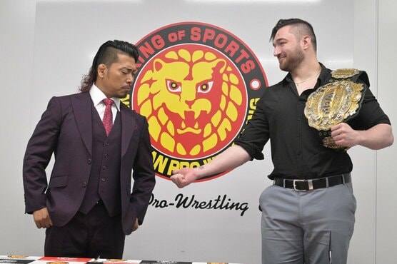 鷹木信悟（左）に腕に入った王冠マークを見せるカラム・ニューマン