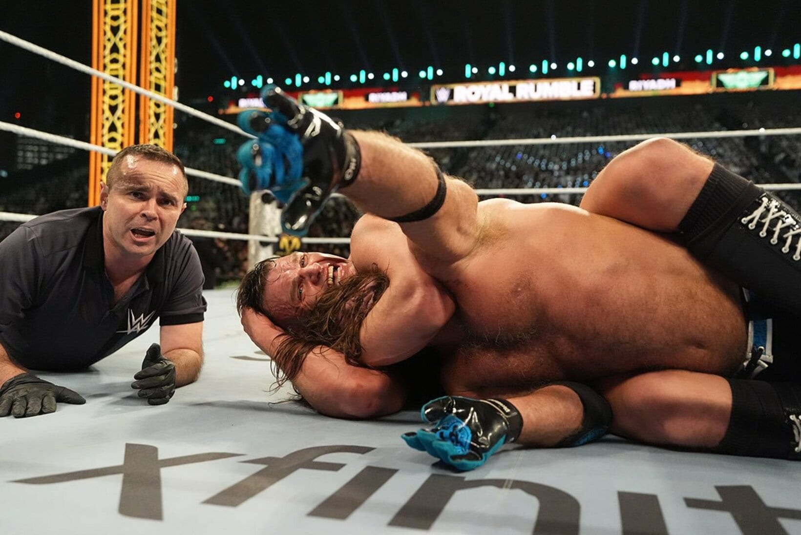 グンター(奥)のスリーパーホールドで絞め落とされたAJスタイルズ（©WWE）