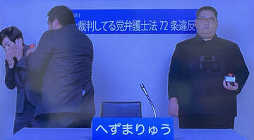  へずまりゅう氏（中）が手話通訳士にメントスコーラで突撃する、右はぷりん将軍（政見放送から）
