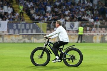 試合前にピッチを自転車で疾走するランゲニック監督（ロイター）