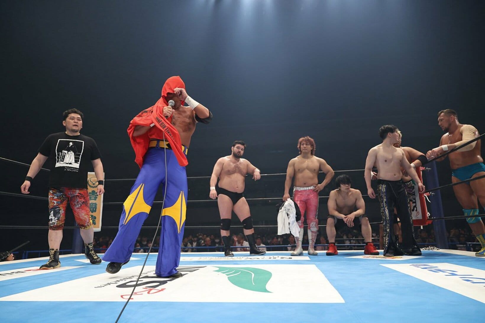 マスクをはぎ取られ、タオルで顔を隠すタイガーマスク(左から２人目)