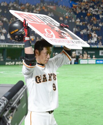  硬い表情で記念ボードを掲げる巨人・亀井