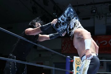 デスペラード（右）の頭に鉄板を振り下ろすDOUKI