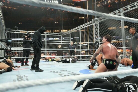 CMパンク（手前右）の前に立った謎の黒覆面 ⒸWWE