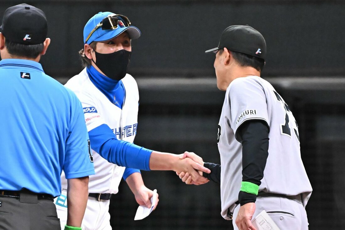 メンバー表交換で日本ハム・新庄監督(左)と握手する巨人・橋上監督代行