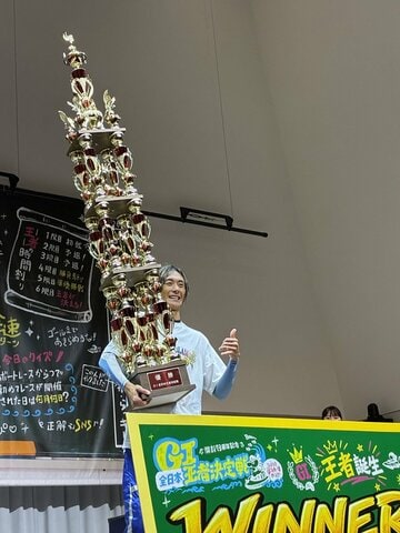 巨大すぎるトロフィーを抱え、笑顔の峰竜太