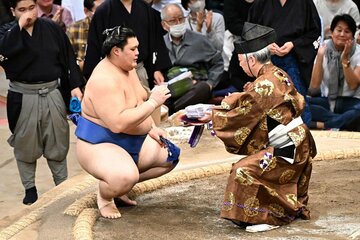 中日で勝ち越しを決め、懸賞を受け取る大の里(左)
