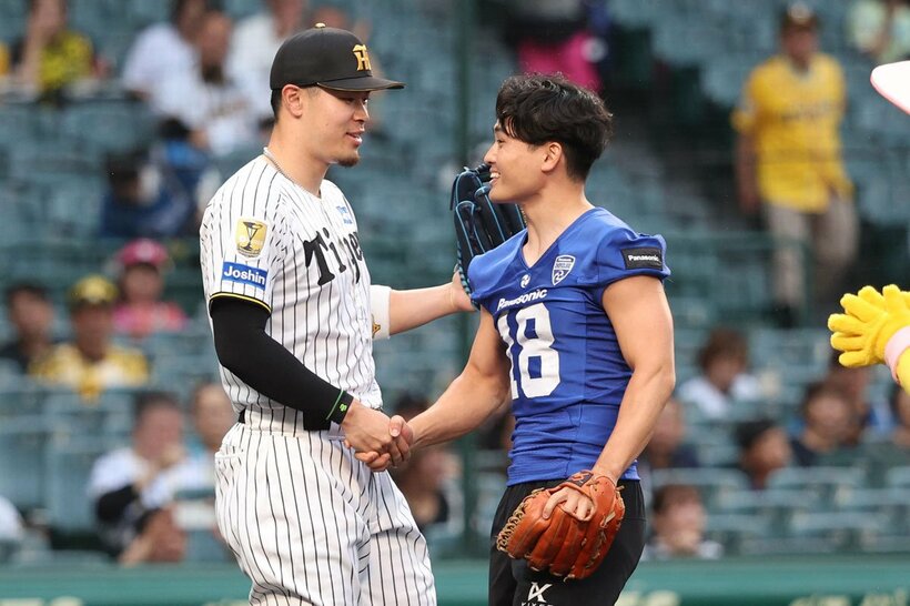 ガッチリ握手する佐藤輝明と桑田理介