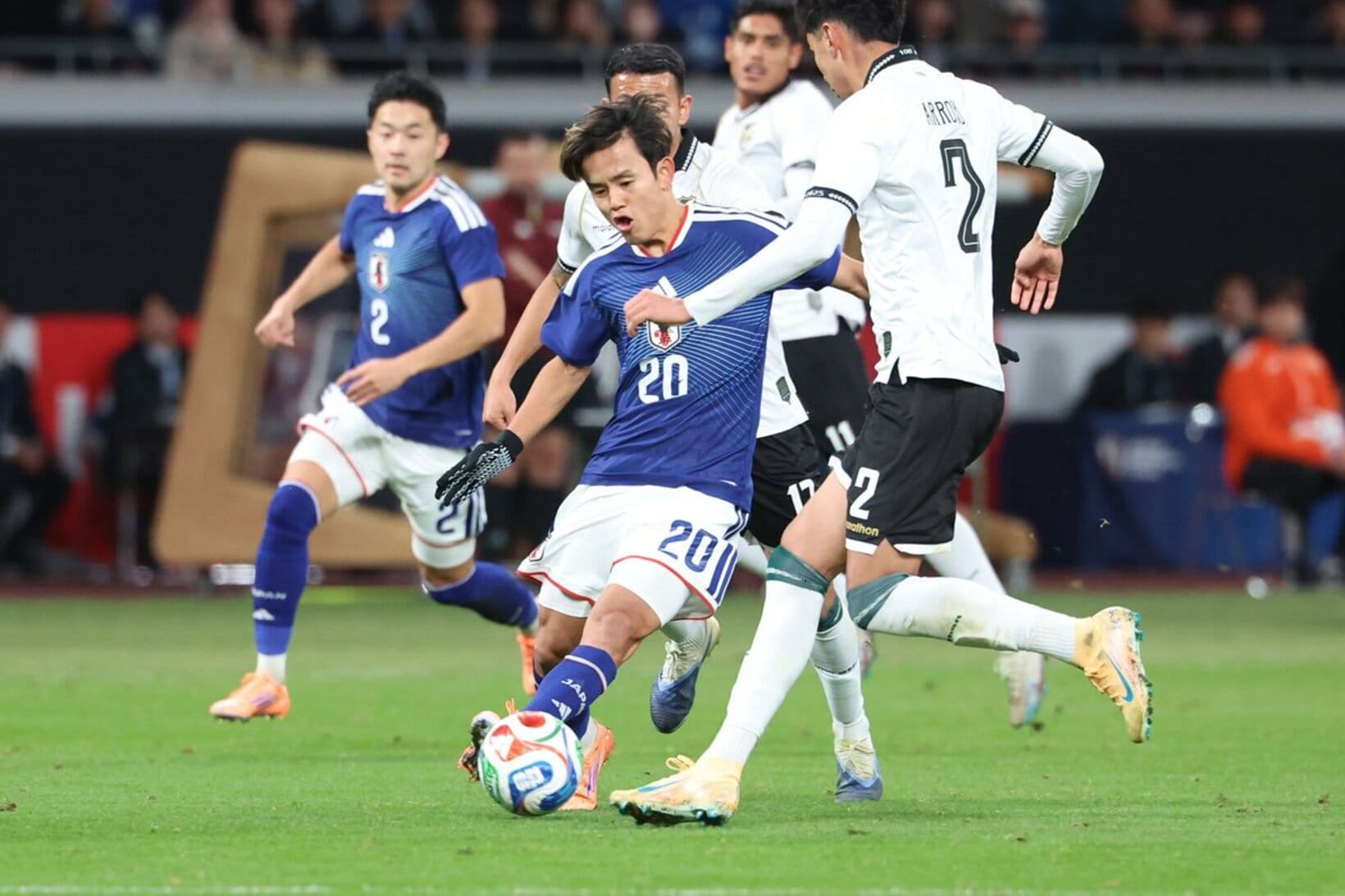 相手ＤＦに囲まれながらもパスを出す久保建