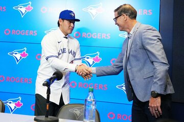 ブルージェイズGMのアトキンス氏(右)と握手する岡本和真（ロイター）