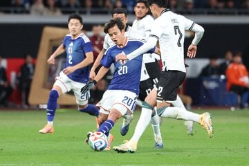 相手ＤＦに囲まれながらもパスを出す久保建