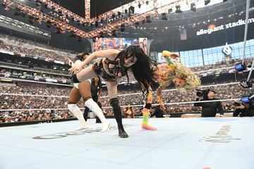 ペイジ（手前）はシャーロット・フレアー（右）とダブルのスーパーキックをラッシュ・レジェンドに叩き込む©WWE