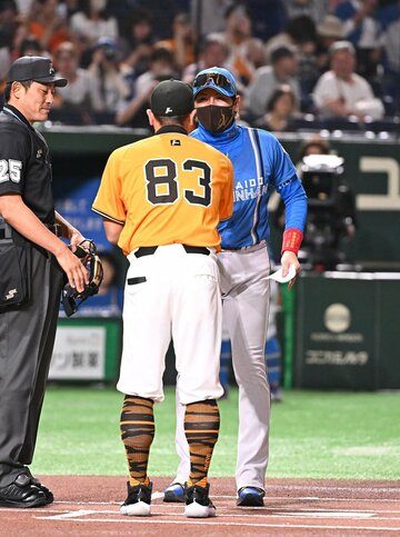 メンバー表交換で握手する阿部慎之助監督（手前）と新庄剛志監督