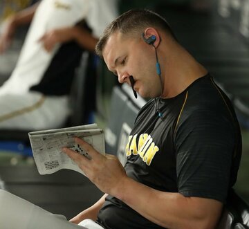  ベンチで新聞を凝視する阪神・サンズ