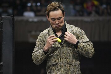 凶器のドライバーを上着のポケットに隠そうとするオカダ・カズチカ（©All Elite Wrestling）
