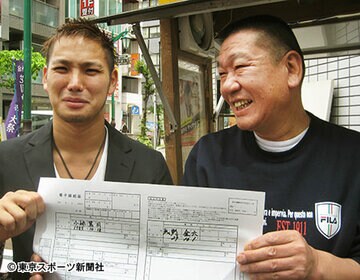 浅野社長（右）との「養子縁組届」にサインした小峠