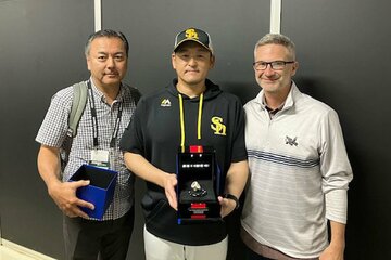レンジャーズ幹部(右)から世界一リングを手渡されたソフトバンク・倉野投手コーチ(中)