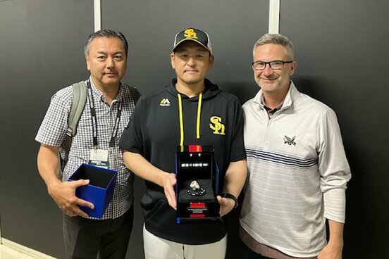 レンジャーズ幹部(右)から世界一リングを手渡されたソフトバンク・倉野投手コーチ(中)