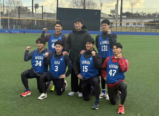 新人選手たちと笑顔で記念撮影に納まる相川監督（中央）