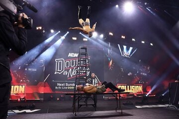 テーブル上でゲバラ(上)の超高層スワントーンボムを浴びるアリン（©All Elite Wrestling）