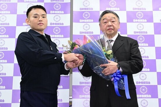 湊川親方(左)から花束を受け取る常盤山親方