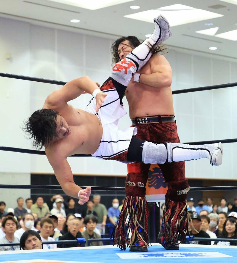 辻陽太(奥)に強烈なフライングニールキックを放つ後藤洋央紀