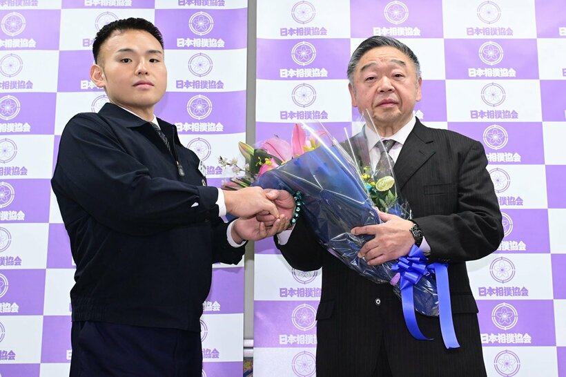 湊川親方(左)から花束を受け取る常盤山親方