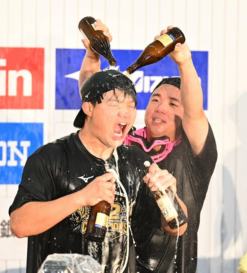 森下翔太(左)にビールをかける阪神・村上頌樹