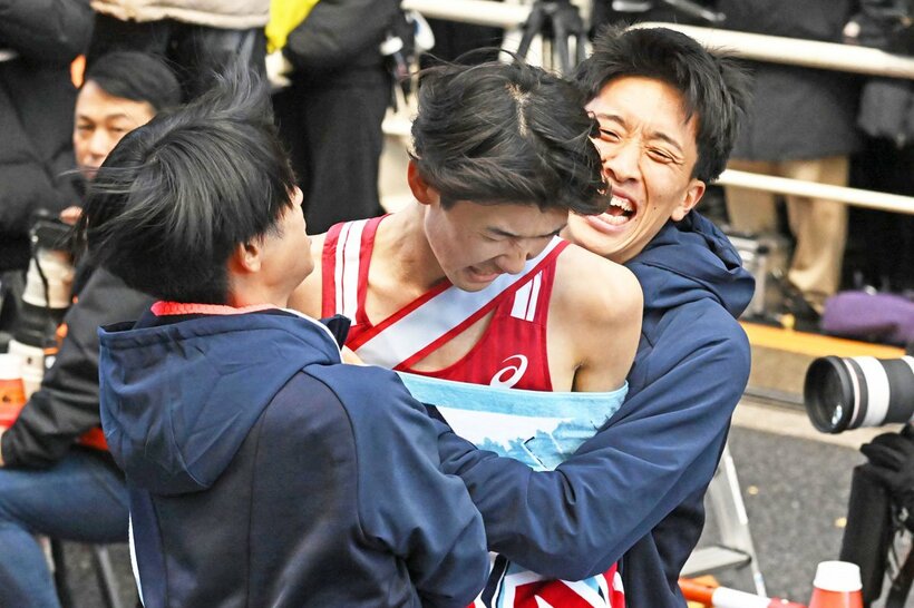総合９位でフィニッシュしたアンカー・鎗田大輝(中)に飛びつく帝京大の選手たち
