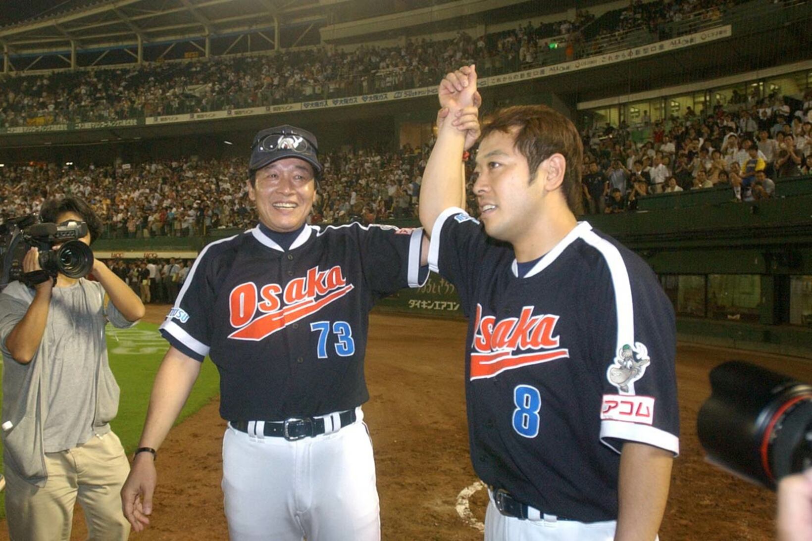 選手会長の礒部（右）をねぎらう梨田監督（２００４年９月）