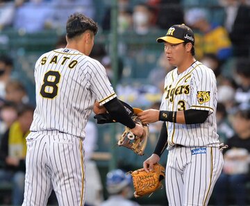  佐藤輝にグラブを渡す大山（右）。そのキャプテンシーにも期待だ