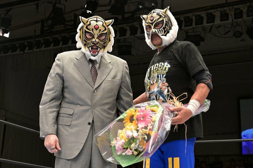 試合後、初代タイガーマスク(左)から花束を受け取ったタイガーマスク