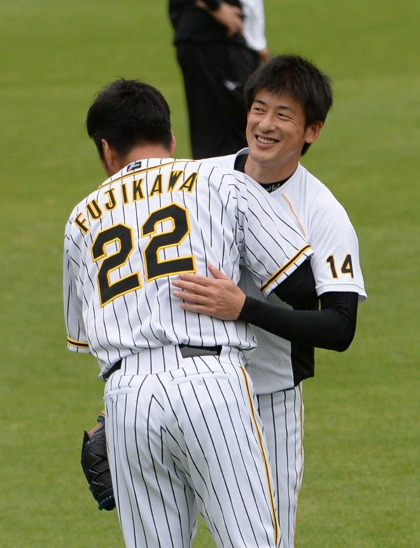  練習前に藤川(左)とハグする阪神・能見