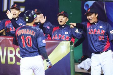 ９回、生還したDeNA・桑原(手前)を笑顔で迎える侍ジャパン・井端監督(中)