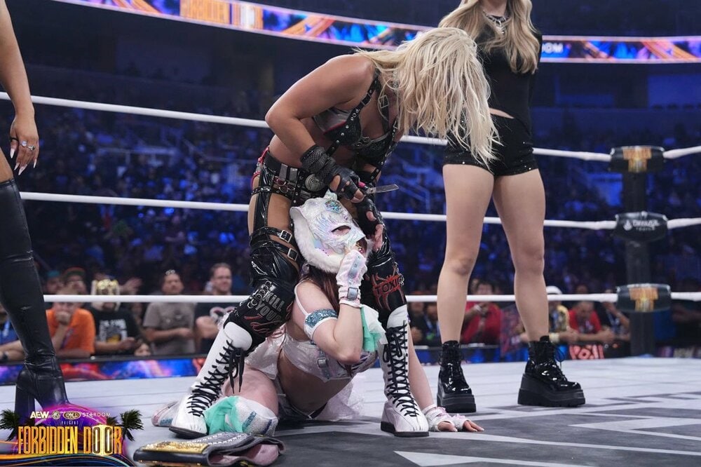 スターライト・キッド(手前)はテクラ(上)にナイフでマスクを引き裂かれる(©All Elite Wrestling)
