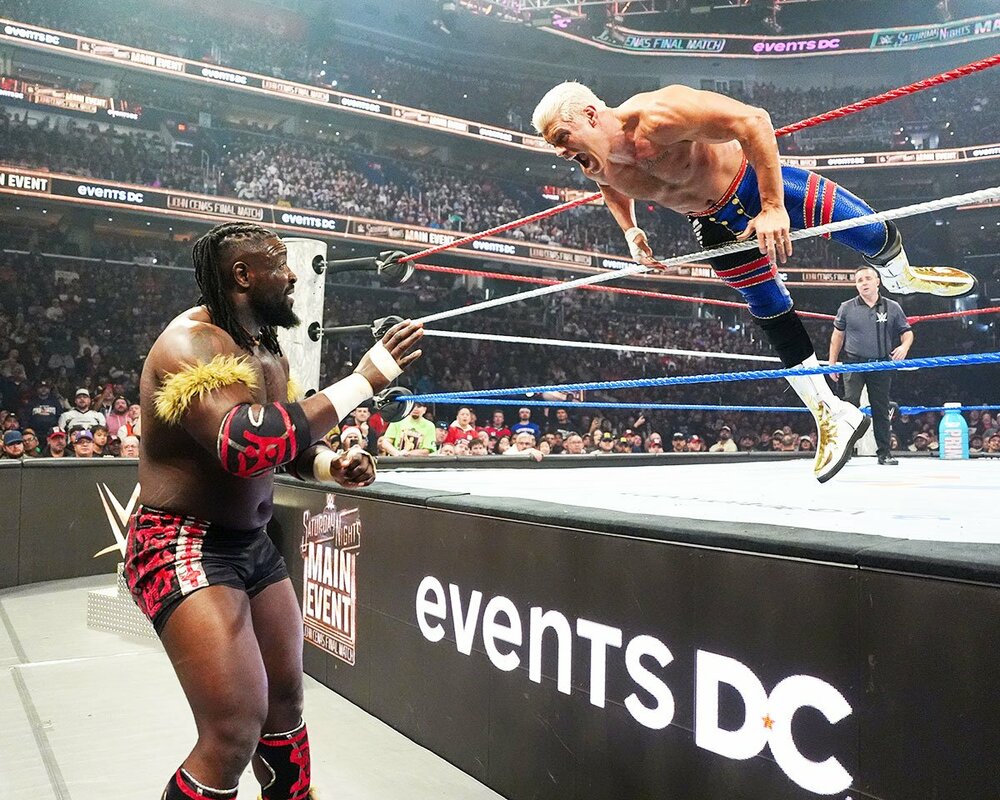 オバ・フェミ(左)にトペ・スイシーダで突っ込むコーディ・ローデス(©WWE)