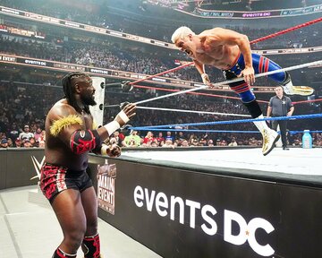 オバ・フェミ(左)にトペ・スイシーダで突っ込むコーディ・ローデス（©WWE）