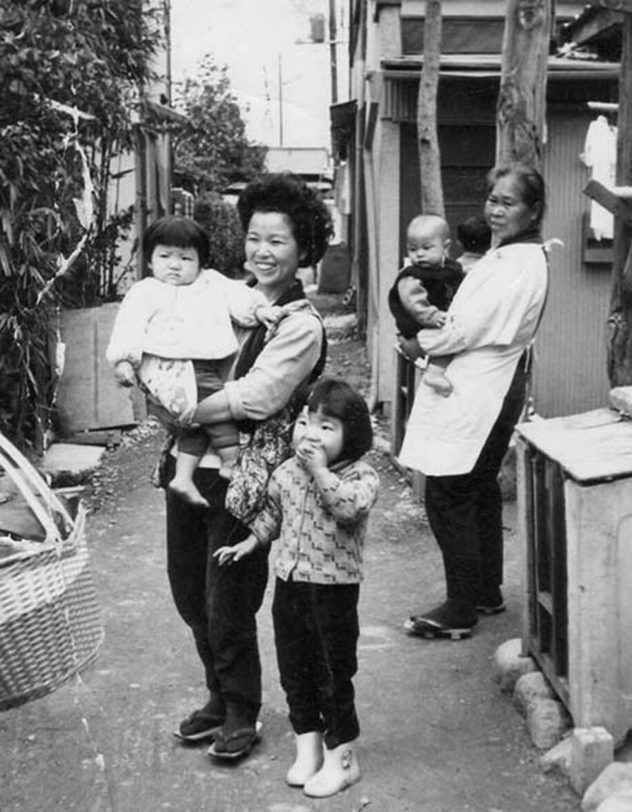  ７歳の時、自宅の前で。昭和の香りが漂う。左から妹・広美さん、母・里子さん、ダンプ（提供写真）