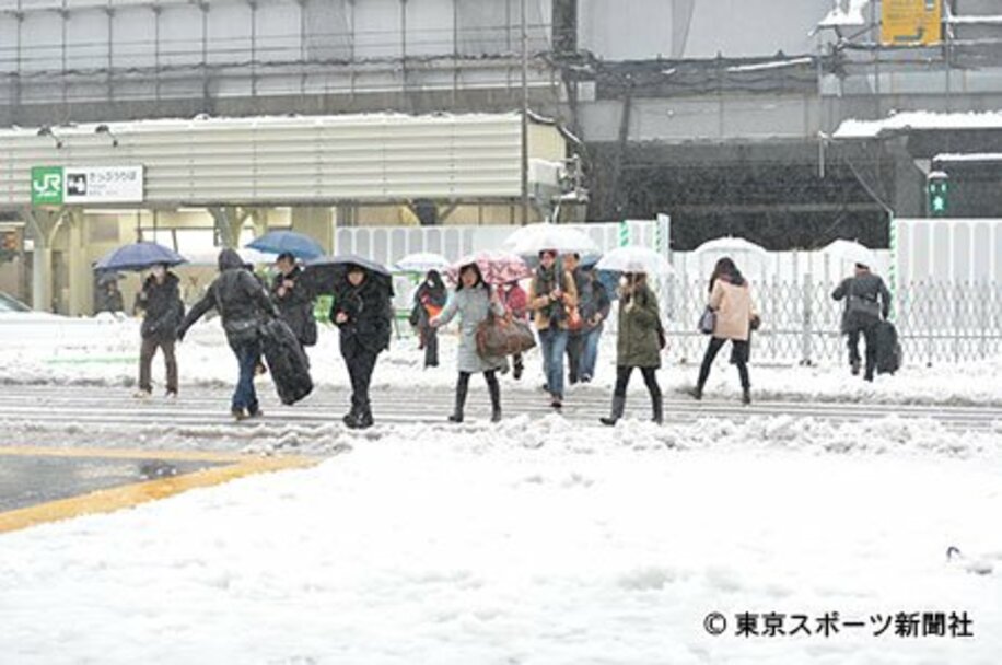 15日朝には雨に変わり、ＪＲ新宿駅前の横断歩道はグチャグチャ