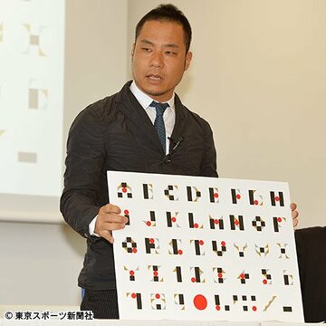 ５日の会見でタイポグラフィーを示した佐野氏