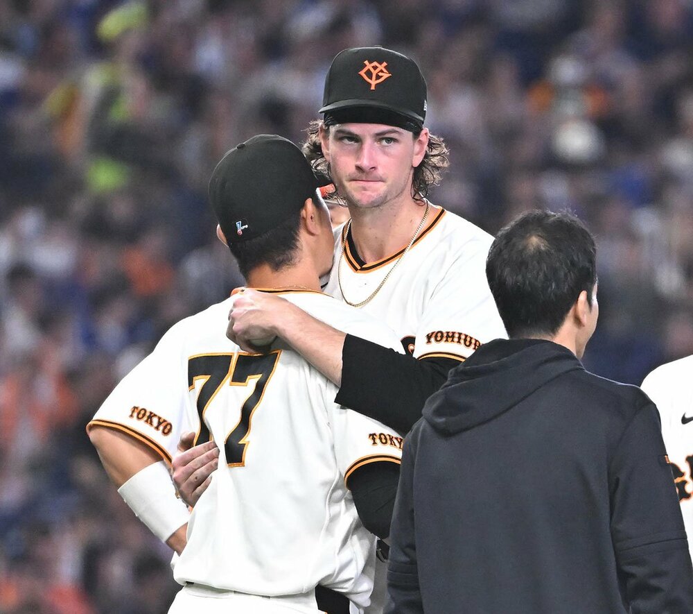 降板時、内海投手コーチ(左)とハグしてベンチへ下がった巨人・ウィットリー