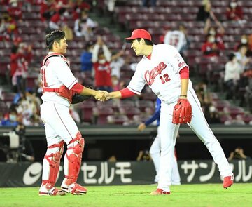  完封で５勝目をあげ、坂倉と握手する広島・九里（右）
