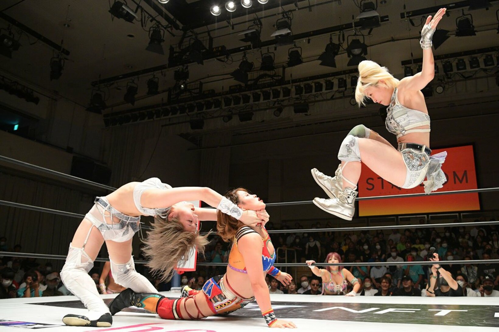 安納サオリ（左）が押さえる月山和香（中）にドロップキックを放つなつぽい